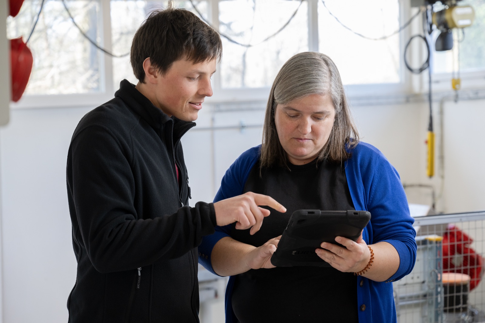 Joana Leitão bespricht mit einem Mitarbeiter Daten auf dem Tablet im Pumpwerk